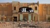 A man walks past the destroyed former customs building, which was used as a base by radical Islamists, in Gao, Mali, February 28, 2013.