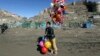A young boy sells balloons in Kabul, March 23, 2017. An aid group said Thursday that nearly a third of all children in war-torn Afghanistan are unable to attend school, leaving them at increased risk of child labor, recruitment by armed groups, early marriage and other forms of exploitation. 