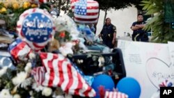 Oficiales de policía en Dallas, Texas, vigilan un improvisado memorial en la sede de la Policía, el domingo, 10 de julio de 2016.