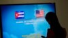 FILE - A journalist stands near a screen announcing a round of negotiations between Cuba and the U.S. in Havana, January 22, 2015.