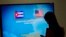FILE - A journalist stands near a screen announcing a round of negotiations between Cuba and the U.S. in Havana, January 22, 2015.