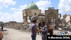 Des hommes devant les ruines de la mosquée al-Nouri à Mossoul, en Irak, le 9 mai 2018.