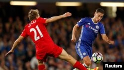 Le footballeur Eden Hazard de Chelsea engagé dans un duel avec Lucas Leiva de Liverpool lors d’un match entre leurs deux équipes de la Premier League anglaise, 16 septembre 2016.