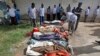 Somalis look at bodies brought to Mogadishu after a number of civilians were killed during a military raid in Barire village, southern Somalia, Aug. 25, 2017.