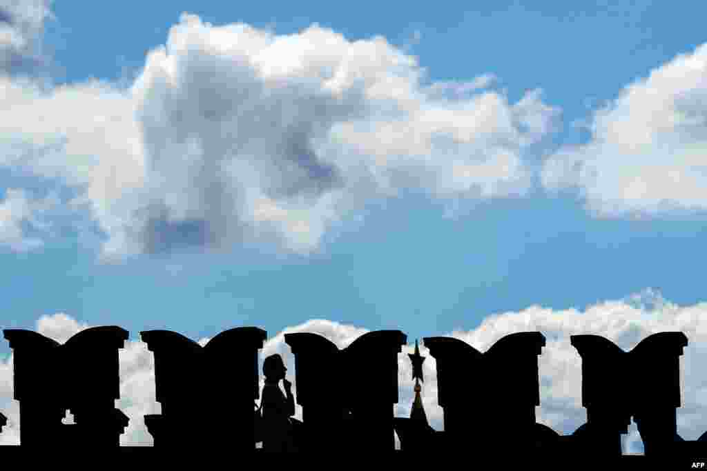 A woman walks on a bridge to the Kremlin in downtown Moscow.