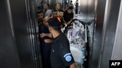 Ekipe hitne pomoći prebacuju tijelo američke državljanke koja je upucana na Zapadnoj obali. (Foto: AFP)