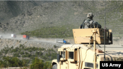 图为美军作战后勤巡逻队在阿富汗公路旁进行巡逻，保卫公路的安全。