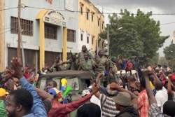 FILE - Malian soldiers celebrate as the arrive at Independence Square in Bamako., Aug. 18, 2020.