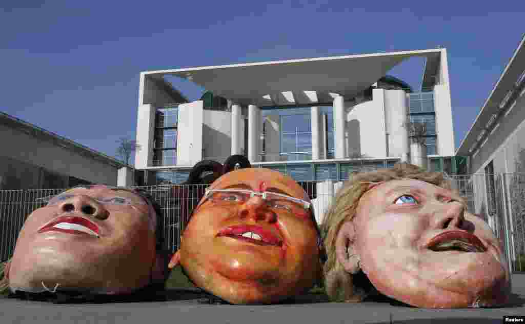 Topeng-topeng karikatur yang menggambarkan Menteri Ekonomi Jerman, Philipp Roesler, Menteri Lingkungan Peter Altmaier dan Kanselir Angela Merkel diletakkan di komplek pemerintahan di Berlin dalam protes menentang emisi karbon dioksida (CO2). 