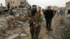 A Palestinian Hamas militant walks in the rubble of the destroyed house of Hamas militant Mohammad Abu Shmala, following an Israeli air strike in Rafah, southern Gaza Strip, November 16, 2012.