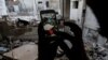 FILE - A Syrian gamer uses the Pokemon Go application on his mobile to catch a Pokemon amidst the rubble in the besieged rebel-controlled town of Douma, a flashpoint east of the capital Damascus, July 23, 2016.