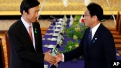 윤병세 한국 외교장관(왼쪽)과 기시다 후미오 일본 외무상이 지난 6월 일본 도쿄에서 회담에 앞서 악수하고 있다. (자료사진)