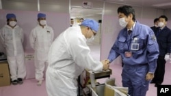 Perdana Menteri Jepang yang baru, Shinzo Abe, di PLTN Fukushima Dai-ichi di Okuma, Prefektur Fukushima, Jepang timur laut (29/12). (AP/Itsuo Inouye)