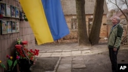 Олександр Туровски, чиј син Свјатослав беше меѓу осумте мажи убиени во Буча, Украина, во март 2022 година, стои пред споменикот каде што беше пронајдено телото на неговиот син