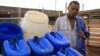 Fresh Life Frontline member Bernard Mutuku stands next to waste collection containers at the processing facility in the industrial area of Nairobi, Kenya, September 11, 2012. (J. Craig/VOA) 