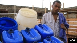 Fresh Life Frontline member Bernard Mutuku stands next to waste collection containers at the processing facility in the industrial area of Nairobi, Kenya, September 11, 2012. (J. Craig/VOA) 