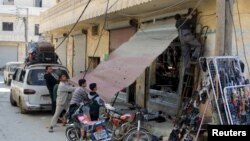 در پی اعلام آتش بس شهروندان حومه حلب برای بازگشایی یک مغازه تلاش میکنند.