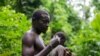 FILE - A Pygmy man from the Bagyeli tribe shows plants used for the traditional treatment of malaria on May 26, 2017, in the Kribi region of Cameroon.