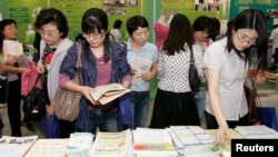 한국 서울에서 열린 여성 취업박람회에서 구직자들이 직업 훈련 센터에서 제공하는 유인물을 들여다보고 있다. (자료사진)