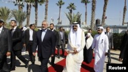PM Palestina Ismail Haniyeh menyambut Emir Qatar Sheikh Hamad bin Khalifa al-Thani (kanan depan) saat tiba di Rafah, Jalur Gaza Selasa (23/10).