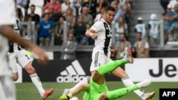 Le gardien albanais de la Lazio, Thomas Strakosha (Bottom), pare une attaque du Portugais de la Juventus Cristiano Ronaldo lors du match championnat italien entre la Juventus et la Lazio, au stade Allianz de Turin, le 25 août 2018. 