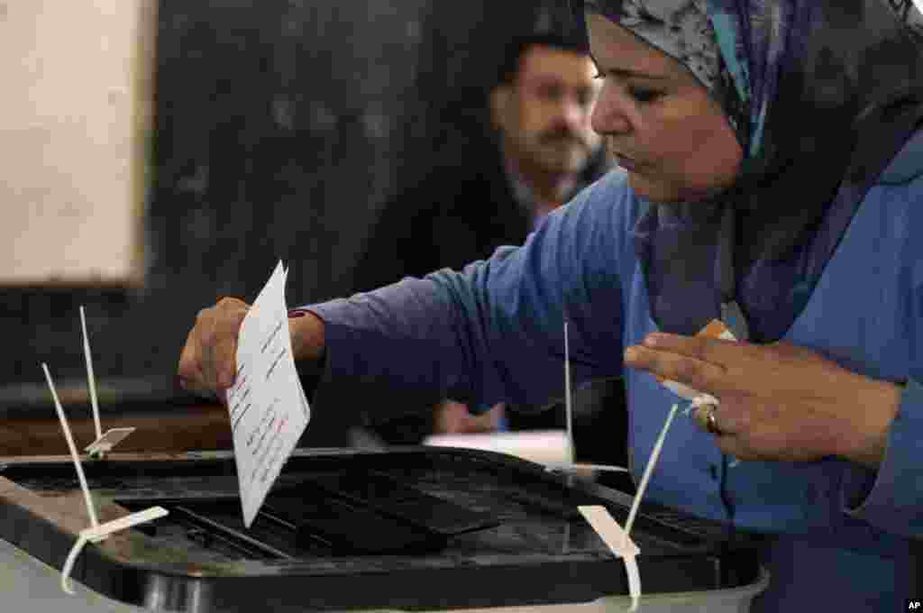 An Egyptian woman casts her vote during the first day of the presidential election in a polling center in Alexandria, Egypt, May 23, 2012. 