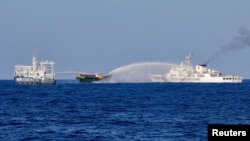 中国海警船向前往南中国海第二托马斯浅滩执行补给任务的菲律宾补给船发射水炮。(2024年5月4日，路透社)
