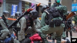 资料照：2020年5月24日，在香港铜锣湾举行的反对国安法的示威活动中，防暴警察拘留了一名抗议者。（美联社）