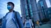 People wearing face masks to protect against COVID-19 walk across a pedestrian bridge near a neighborhood with a suspected coronavirus case in Beijing, Sept. 15, 2021. 