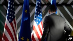 资料照：一名工作人员在布鲁塞尔欧洲委员会办公楼里检查欧盟与美国旗帜。（2023年4月4日）