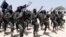 FILE - Al-Shabab fighters march during military exercises in the Lafofe area, some 18 kilometers (11 miles) south of Mogadishu, Somalia, Feb. 17, 2011.
