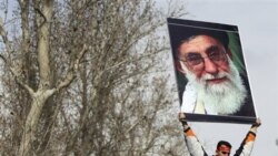 یک حامی دولت در مراسم تشییع جنازه صانع ژاله تصویر آیت الله خامنه ای را بلند کرده است. قانع ژاله، عضویت برادرش صانع ژاله در بسیج را تکذیب کرد - ۱۶ فوریه ۲۰۱۱