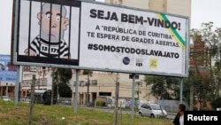 A man walks past a billboard that describe the former Brazilian President Luiz Inacio Lula da Silva in a jail, one week before his testimony to the federal judge Sergio Moro, in Curitiba, Brazil, May 5, 2017. Sign reads "Welcome! The republic of Curitiba awaits you with open jail." 