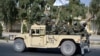 Taliban forces from the Al-Badr military corps sit on armed vehicles during a parade in Kandahar on Nov. 8, 2021.