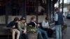 FILE - Young people hang out outside a restaurant in Stockholm, Sweden, April 8, 2020.