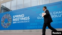  Yon nonm kap mache devan biwo Fon Monetè Entènasyonal la, FMI, nan Washington, 8 avril 2019. Foto: REUTERS/Yuri Gripas