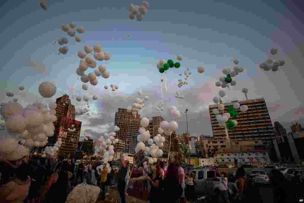 레바논의 항구 도시 베이루트에서 지난 8월 발생했던 대형 폭발 사고로 인해 숨진 190여명의 희생자들을 추모하기 위해 사고 현장에서 사망자의 이름이 적힌 풍선을 하늘로 날리고 있다. 