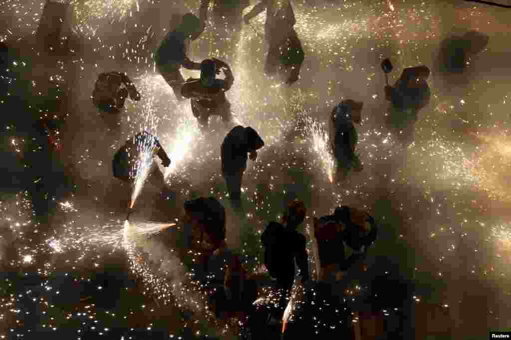 Revelers play with fireworks in an enclosed area on the main street of the village of Paterna, near Valencia, during the annual &quot;Corda&quot; festivity in Spain, Aug. 26, 2013.