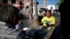 FILE - Men play cards in Mariachi Plaza in the Boyle Heights area of Los Angeles, home to many Mexican and Central American migrants.