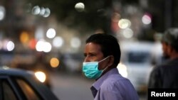 A man wearing a protective mask walks outside a shopping area, as the outbreak of coronavirus disease (COVID-19) continues, in Karachi, Pakistan December 29, 2020. REUTERS/Akhtar Soomro/File Photo
