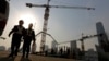 Workers walk out from a construction site at the Central Business District of Beijing, China, Jan. 20, 2015.