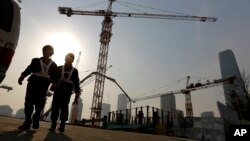 Workers walk out from a construction site at the Central Business District of Beijing, China, Jan. 20, 2015.