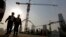 Workers walk out from a construction site at the Central Business District of Beijing, China, Jan. 20, 2015.