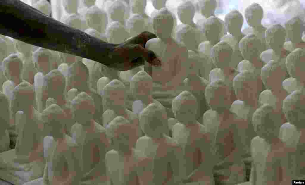 Seorang pria mengambil sebuah patung Buddha, menjelang perayaan Hari Raya Waisak yang diperingati oleh umat Budha Sri Langka sebagai Hari Lahir, Pencerahan dan Wafatnya Buddha, di Colombo.