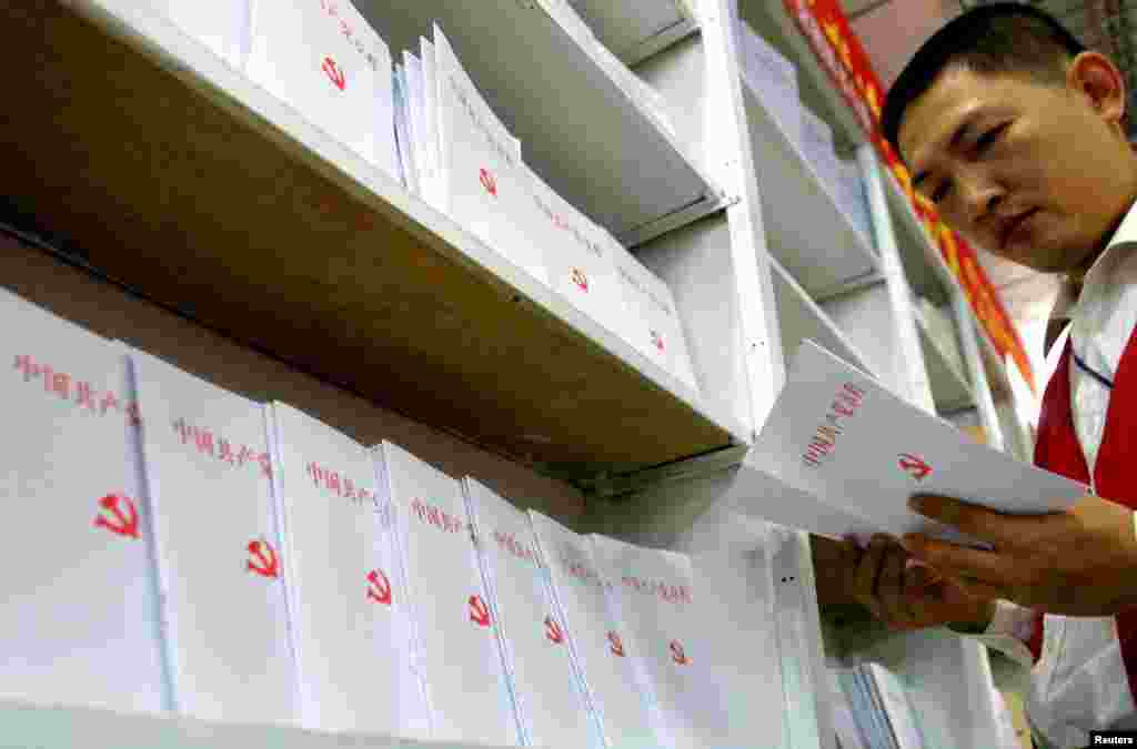 一男子在书店翻阅中国共产党党章(2002年11月21日)。江泽民的三个代表思想写入中共党章