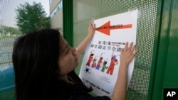 一名中国留学生2015年8月22日在美国达拉斯的德克萨斯大学校园内张贴给中国留学新生开设讲座的指路标志。