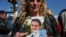 The wife of sailor Fernando Villarreal, a crew member of the missing submarine, shows his picture as she prays at the naval base in Mar de Plata, Argentina, Friday, Nov. 24, 2017.