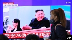 A woman passes by a TV screen showing an image of North Korean leader Kim Jong Un and his sister Kim Yo Jong during a news program at the Seoul Railway Station in Seoul, South Korea, Saturday, May 2, 2020. Kim made his first public appearance in 20…