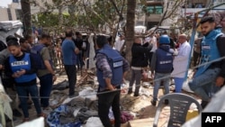 ፍልስጤማውያንና የመገናኛ ብዙሃን ባለሙያዎች በጊዜያዊ መጠለያ ላይ የደረሰውን ጉዳት በመመልከት ላይ (ፎቶ ኤፒ መጋቢት 31፣ 2024) 