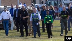 ບັນ​ດາ​ເຈົ້າ​ໜ້າ​ທີ່​ບັງ​ຄັບ​ໃຊ້​ກົດ​ໝາຍ​ເດີນ​ທາງ​ຮອດ​ໂຮ​ງ​ຮຽນ​ມັດ​ທະ​ຍົມ ອາ​ປາ​ລາ​ຈີ ເພື່ອ​ຈັດ​ກອງ​ປະ​ຊຸມ​ຖະ​ແຫຼງ​ຂ່າວ, ເມືອງ ວິນ​ເດີ, ລັດ ຈໍ​ເຈຍ, 3 ກັນ​ຍາ 2024.